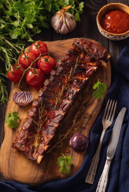 Koyu ahşap arka planda sebzeli ızgara domuz kaburgası.