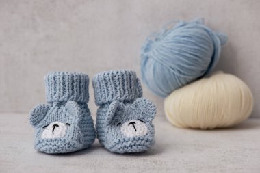 Handmade knitted baby booties in blue colours.