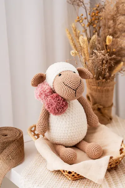El yapımı oyuncak koyun, amigurumi. El yapımı yumuşak oyuncak.