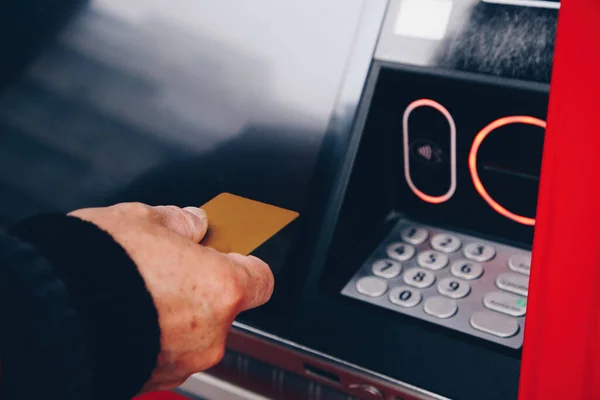 ATM makinesinden para çekmek için kredi kartını kullanan kişinin kapatılması, endişe duymadan yapılan işlemler, maddi rahatlığınızın sağlanması.