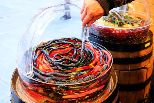 Mağazadaki renkli plastik kaseler, renkli şeker çeşitleriyle dolu canlı plastik kaseler, enfes bir mağazada cazip bir gösteri yaratıyor..