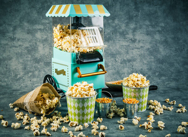 Попкорн машина и стакан пива на сером фоне. Toned.