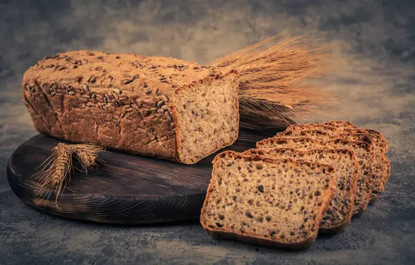 Frisch Gebackenes Brot Und Weizenähren Auf Rustikalem Hintergrund Getönt — Stockfoto