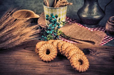 Tahta bir masada kurabiye ve buğday kulakları. Ayarlanmış.