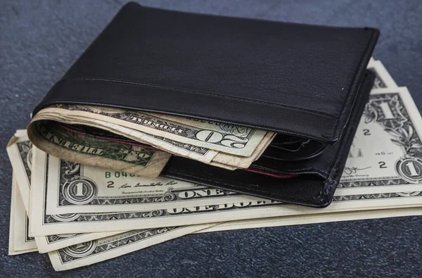 アスファルトの背景にドル札付きブラックレザー財布 トーン — ストック写真