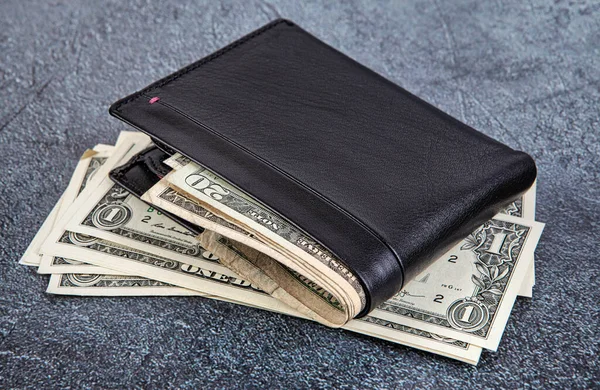アスファルトの背景にドル札付きブラックレザー財布 トーン — ストック写真
