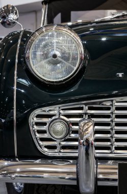 Bir araba fuarında sergilenen eski klasik bir arabanın farları.