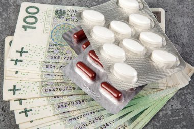 Polonyalı Zloty PLN 'nin arka planında haplar ve kapsüller. Pahalı ilaç konsepti.