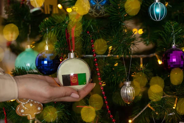 Крупным Планом Девушки Держат Руках Рождественский Шар Елки Флагом Афганистана — стоковое фото