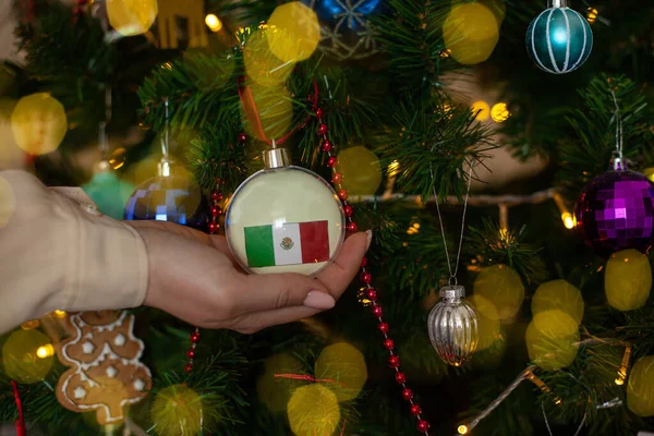 Крупным Планом Девушки Держат Руках Рождественский Шар Елки Флагом Мексики — стоковое фото