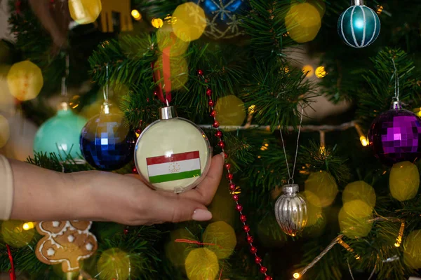Крупным Планом Девушки Держат Руках Рождественский Бал Елки Флагом Таджикистана — стоковое фото