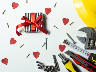 İnşaat aletleri ve beyaz arka planda küçük kırmızı kalpler ve kopyalama alanı. Sevgililer Günü için inşaat tebrik kartı. Evi sevgiyle onar. Sevgililer için hediyeler. Erkeklere hediye almak..