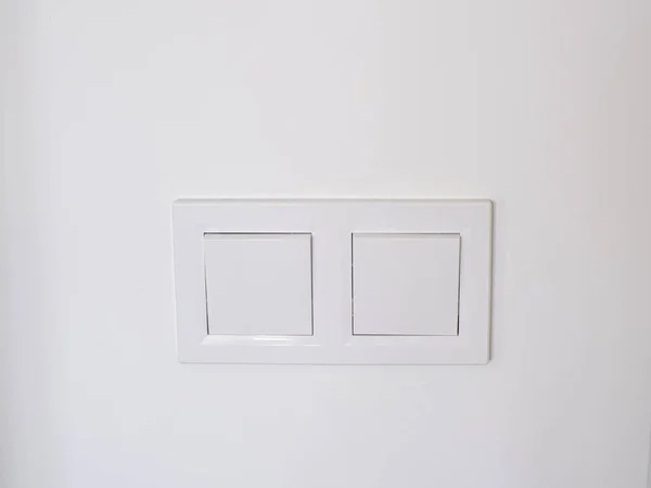 白い壁に設置された2つのライトスイッチ ダブルホワイトプラスチック機械式スイッチ オンとオフを切り替えます コピースペース 省エネルギーの概念 白い電源スイッチで部屋の中のきれいな壁 — ストック写真