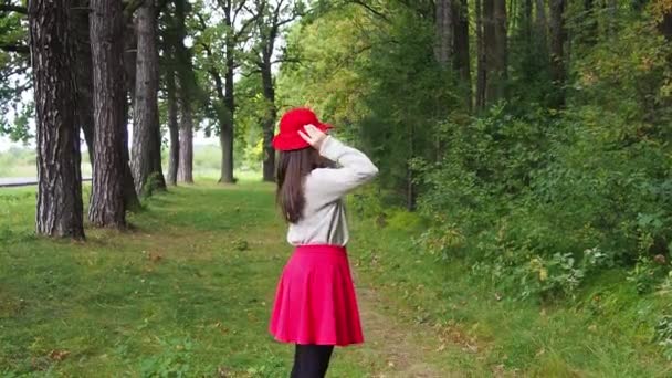 Jong Meisje Zet Rode Hoed Haar Hoofd Corrigeert Lang Donker — Stockvideo