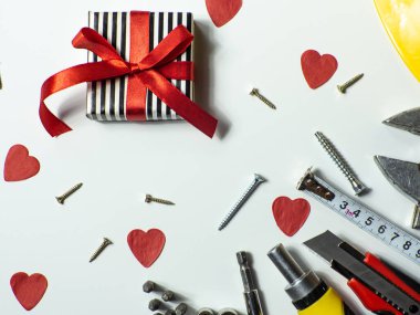 İnşaat aletleri ve beyaz arka planda küçük kırmızı kalpler ve kopyalama alanı. Sevgililer Günü için inşaat tebrik kartı. Evi sevgiyle onar. Sevgililer için hediyeler. Erkeklere hediye almak..