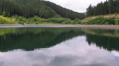 Karpat dağlarında göl bulutlu bir yaz günü. Bukovel, Ukrayna 'daki ormanda küçük boş bir göl. Çakıl taşlı temiz su. Dağlardaki Idyllic manzarası.