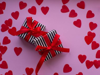 Kırmızı kalp kağıdında iki paket var. Tebrik kartı, hediye. Sevgililer Günü tatili konsepti. Bir sürü kalp şeklinde kâğıdı ve yazı için yeri olan düz bir yer. 14 Şubat.