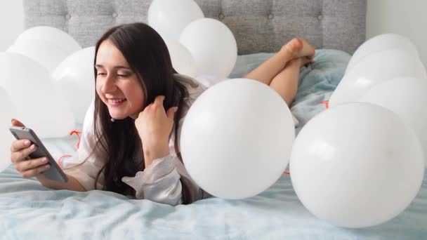 Woman White Clothes Lying White Color Balloons Bed Portrait Smiling — Videoclip de stoc
