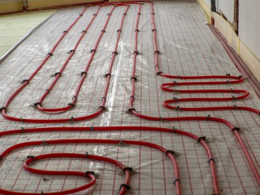 Yeni bir ev inşaatında yer altı ısıtması. Boru tesisatçısı ısıtma sistemi kuruyor. Su tabanındaki ısıtma sistemi. Tadilat sırasında apartmandaki boru tesisatı..