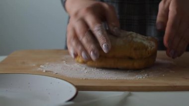 Kadın ahşap bir masada hamur yoğuruyor. Ev yapımı hamur işleri. Paskalya için pasta ya da el yapımı kurabiyeler hazırlıyorum. Noel için zencefilli ekmek pişiriyorum. Kadın fırıncının ellerine yakın bisküvi yapıyorlar..