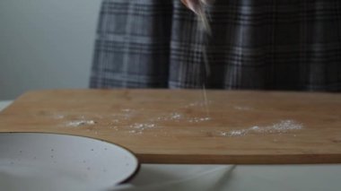 Kadın hamur yapmak için un serpiştirilmiş ahşap bir masa. Paskalya için pasta ya da el yapımı kurabiyeler hazırlıyorum. Noel için zencefilli ekmek pişiriyorum. Kadın fırıncının ellerine yakın bisküvi yapıyorlar..