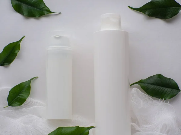 Concepto Bienestar Belleza Set Dos Botellas Blancas Hojas Verdes Sobre — Foto de Stock