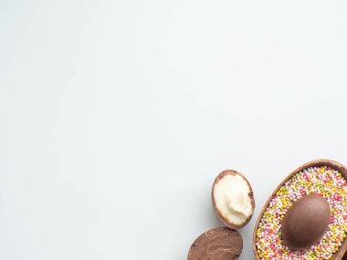 Tatlı Paskalya konsepti. Beyaz arka planda tatlı süprüntülü çikolatalı paskalya yumurtaları ve fotokopi alanı. Paskalya bayramı için bir tebrik kartı tasarlamak. Düz yatıyordu. Tatil için hazırlık.