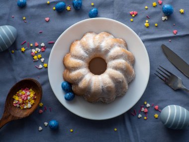 Paskalya pastası dekorasyonu. Yemek pişirme kutlaması konsepti. Düz yatıyordu. Paskalya için renkli karamel serpin. Paskalya arkaplanı turta, yumurta, çiçek ve şeker parçacıkları. Tatil kompozisyonu