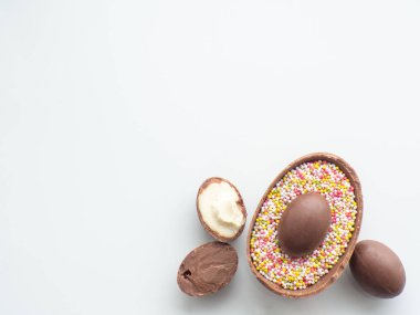 Tatlı Paskalya konsepti. Beyaz arka planda tatlı süprüntülü çikolatalı paskalya yumurtaları ve fotokopi alanı. Paskalya bayramı için bir tebrik kartı tasarlamak. Düz yatıyordu. Tatil için hazırlık.