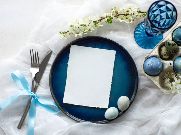 stock image Festive Easter table setting with card, painted eggs and spring flowers on white background. Elegance pastel and blue tablescapes. Easter celebration. Delicate Easter composition. View from above.