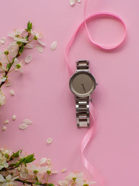 stock image Womens hand watch on pink background with cherry flowers and copy space. Womens, Valentines and Mothers Day gift. Concept of beauty, elegance and femininity. Buying birthday gifts online.