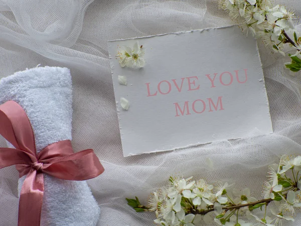 樱桃花小枝 带粉色蝴蝶结的毛巾和白色背景的 爱你的妈妈 母亲节礼物 健康的概念 Spa和放松 给妈妈买礼物 — 图库照片