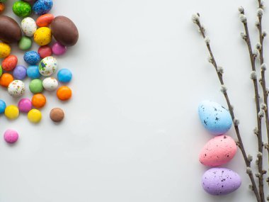 Tatlı Paskalya konsepti. Renkli ve çikolatalı paskalya yumurtaları. Beyaz arka planda tatlı bir sürahi ve fotokopi alanı var. Paskalya bayramı için bir tebrik kartı tasarlamak. Düz yatıyordu. Tatil için hazırlık.