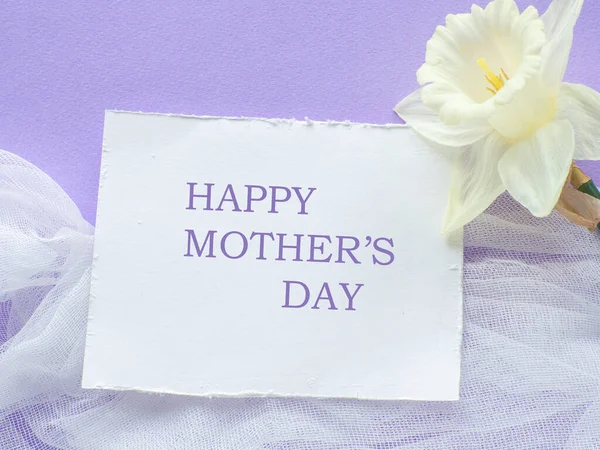 在紫丁香的背景上 点缀着 快乐妈妈日 的花朵和卡片 母亲节贺卡 纸片的文字和水仙紫色背景 恭喜你平躺在床上 — 图库照片