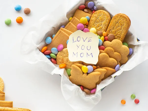 把饼干和糖果放在篮子里 还有爱你的妈妈的字条 母亲节的概念 情人节或母亲节的手工护理包 附有糖果 粥和饼干的季节性礼品盒 — 图库照片