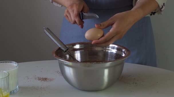 一个女人在面糊里加一个鸡蛋 作为金属弓中的蛋糕 蛋糕或布朗尼 为生日蛋糕准备面团 做松饼 海绵蛋糕的步骤 烘焙过程一步一步 — 图库视频影像