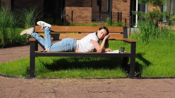 Jolie Femme Brune Assise Sur Banc Lisant Livre Dans Parc — Video