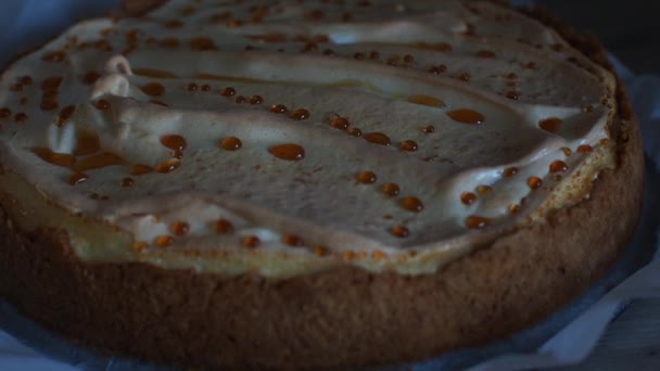 ホワイトペーパーの背景に合併した古典的なチーズケーキ カラメルドロップで自家製チーズケーキ デザートやケーキを調理する コンセプト トップビュー — ストック動画