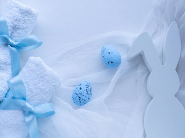 Sağlıklı Paskalya konsepti. Beyaz havluları kurdele, mavi yumurta ve tavşan şeklinde kurdele ile bağla. Beyaz Paskalya kartı. Spa salonunda havlu sardım. Hijyen ve spa, tatil hediyesi olarak rahatlama.