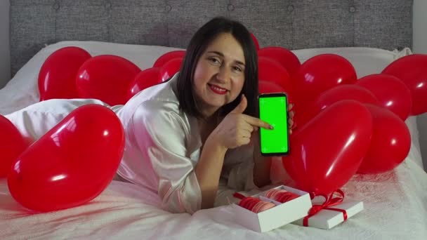 Egy Fekszik Telefonál Piros Szív Alakú Lufik Között Ágyon Lány — Stock videók