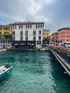 Peschiera del Garda, Italy - June 22, 2024: Landscape of Peschiera del Garda in the province of Verona in Veneto. The main canal in a town on Garda Lake. Sunset view of Canale di Mezzo in Italian town clipart