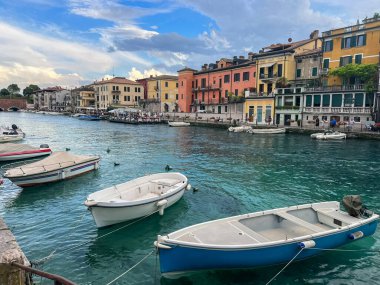 Peschiera del Garda, Italy - June, 2024: Landscape of Peschiera del Garda in the province of Verona in Veneto. The main canal in a town on Garda Lake. Sunset view of Canale di Mezzo in Italian town clipart