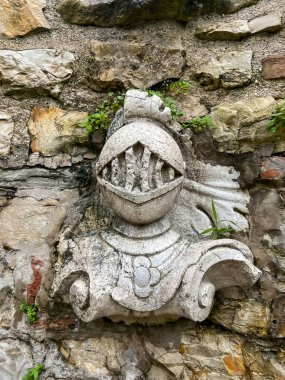 İtalya 'nın Brescia şehrindeki kalenin duvarında bir şövalyenin mermer büstü. Şövalye Koruyucuları Taş Heykeller ve Çatlak Grunge Duvarı.