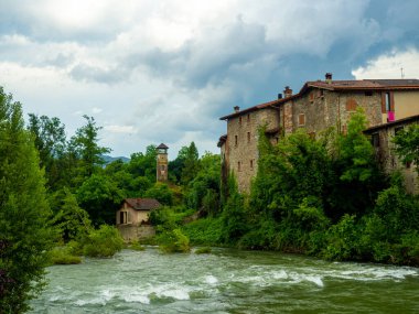 Cityscape with river and village of Sabbio Chiese, Brescia, Italy. Beautiful mountain village in Sabbia Valley in northern Italy. A medieval town in Lombardy. clipart