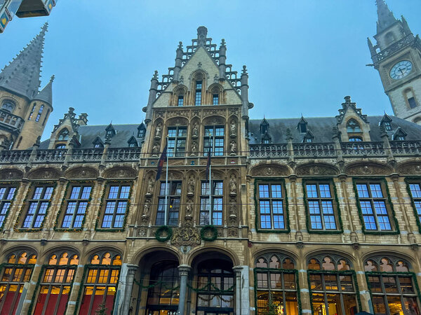 The stunning facade of the main post office building in ghent, belgium, beautifully illuminated at dusk. This architectural gem showcases intricate details and a charming atmosphere.
