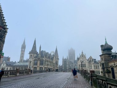 Gent, Belçika, 30 Kasım 2023: Gent 'te tarihi ve modern mimariyi harmanlayan sisli panoramik bir manzara gösteren çarpıcı yağmurlu bir gün. Seyahat ve şehir fotoğrafçılığı temaları için mükemmel.