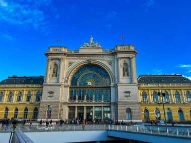 Budapeşte, Macaristan 11 Aralık 2023: Budapeşte 'deki Fransız tarzı bir tren istasyonunun ihtişamı, etkileyici mimarisini mavi gökyüzünün arka planına karşı sergiliyor. Büyük giriş odak noktasıdır..