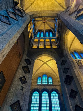 Gotik bir katedralin canlı mavi renkli camlar ve aşağıdan çekilen ve mimari ihtişamı ve karmaşık ayrıntıları vurgulayan yükselen bir kubbeli çatı içeren nefes kesici bir görüntüsü..
