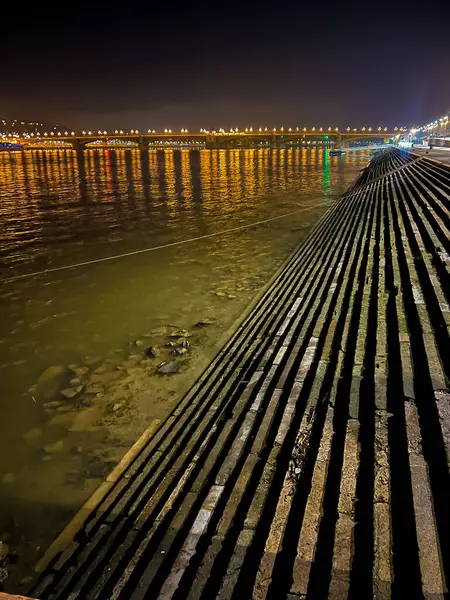 Tuna Nehri 'ndeki uzun bir rıhtımın göz kamaştırıcı gece manzarası. Suyu güzel yansıtan parlak aydınlatmalarla süslenmiş. Büyüleyici ve davetkar bir atmosfer yaratıyor..
