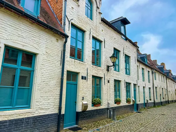 Leuven 'deki eski bir konağın büyüleyici dış görünüşü el değmemiş beyaz tuğla duvarlar, parlak mavi pencere çerçeveleri ve çarpıcı gök mavisi kapılar, tarihin ve rengin güzel bir harmanı..